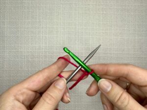 Form an X with your needle and crochet hook, your crochet hook should be on top and pointing left. Your needle should be underneath and pointing right.