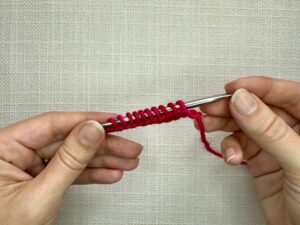 Cut the waste yarn and pull the end through the open loop.