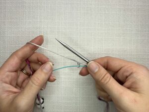 Provisional Cast On Without Crochet Hook: Using your working yarn create a slipknot and add it to the spare cord, keeping it loose enough to slide over a needle later on.