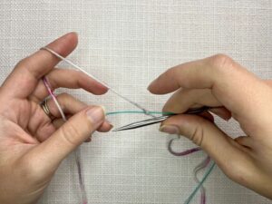 Provisional Cast On Without Crochet Hook: To create a stitch, bring your needle forward and under the cord around to the back. Continue the motion up and over your yarn.