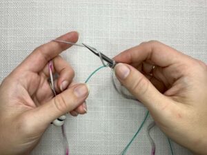 Provisional Cast On Without Crochet Hook: Add a yarn over (YO) by moving the yarn up over the needle from front to back.