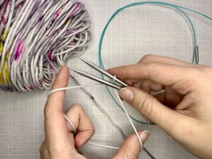Provisional Cast On Without Crochet Hook: Take the top yarn and go under both needles.