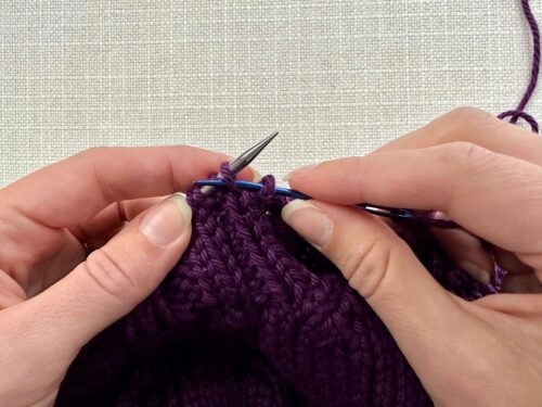 Insert your tapestry needle into the next knit stitch purlwise and leave it on your knitting needle. Pull your yarn all the way through, ensuring the yarn is behind your needles.